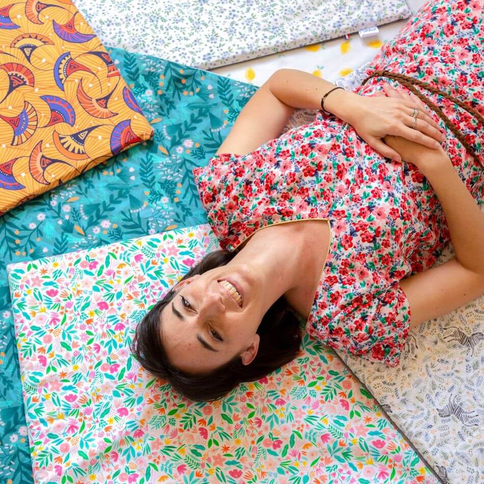 Femme souriante sur plusieurs tapis d'éveils colorés