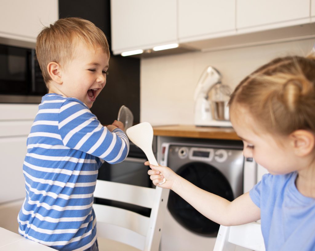 routine vacances enfants et tâches ménagères frère et sœur qui jouent dans la cuisine